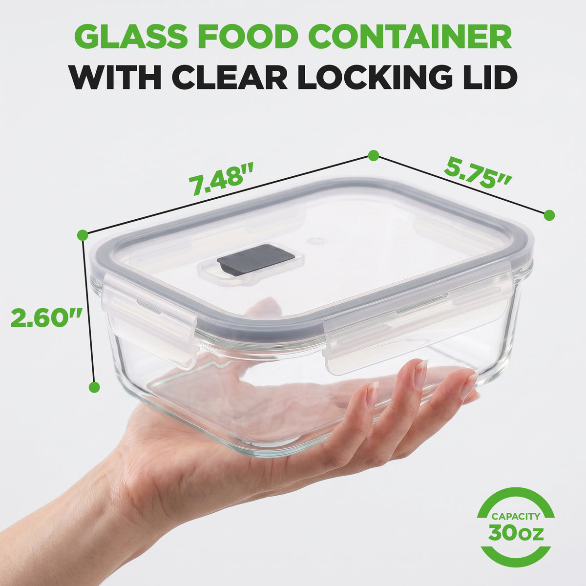 A hand holds a clear glass food container with a clear locking lid against a white background, with green dimension lines showing 7.48 inches, 5.