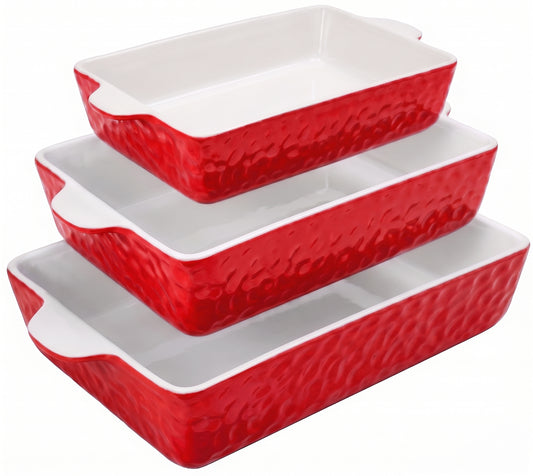 Set of three red ceramic baking dishes with textured surface on a white background