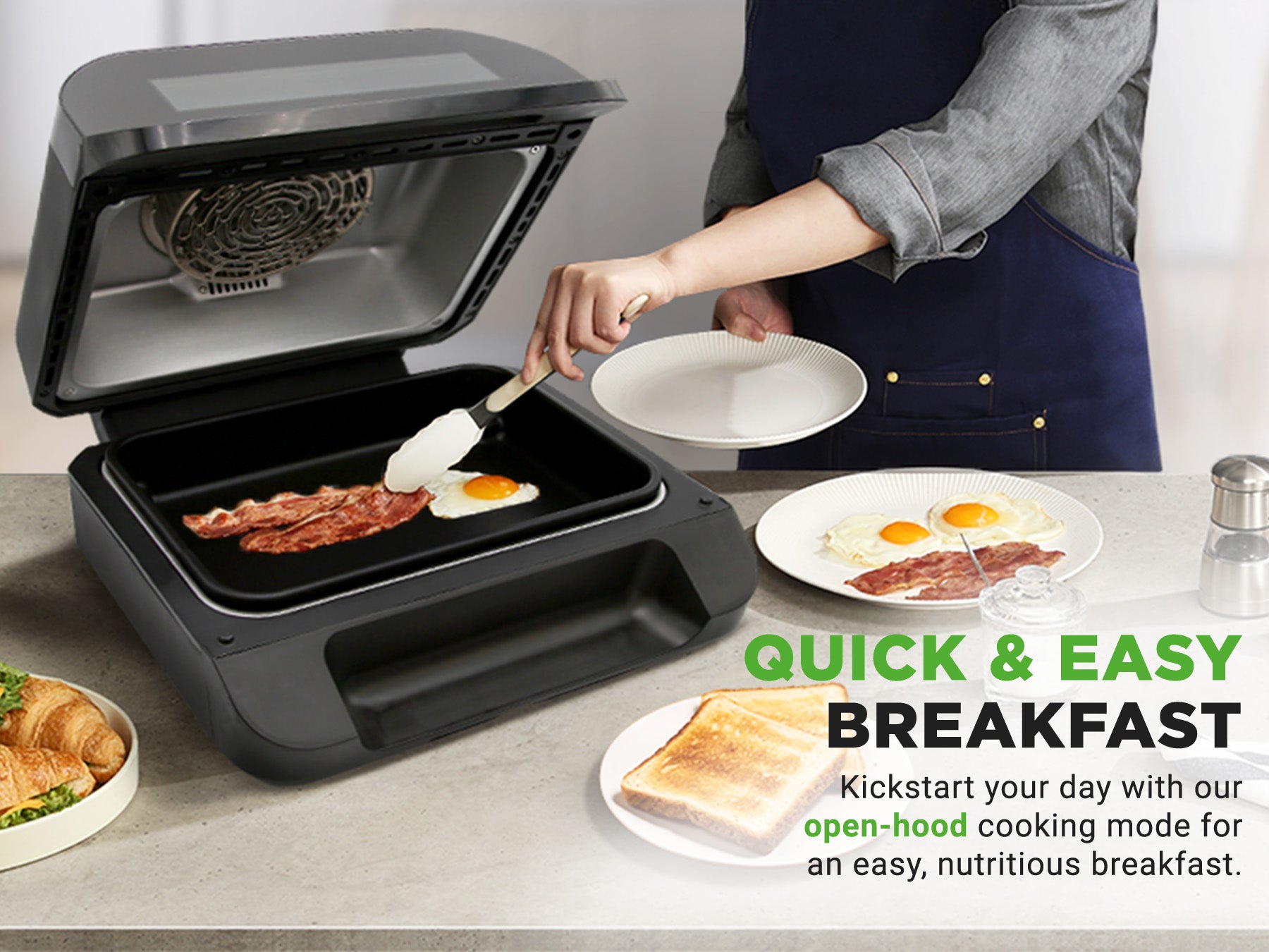 Person preparing breakfast using the air fryer smart grill with plates of food on a table.