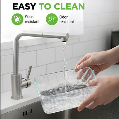 A clear rectangular glass storage container being filled with water from a stainless steel faucet in a kitchen sink. Text at the top says 'EASY TO CLEAN' with icons for stain resistant and odor resistant.