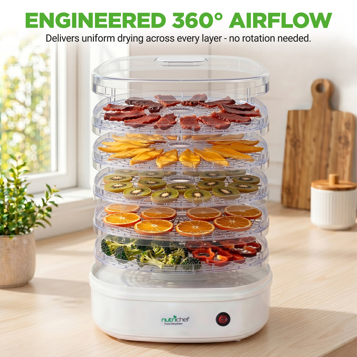 NutriChef food dehydrator with various fruits and vegetables on a kitchen counter.